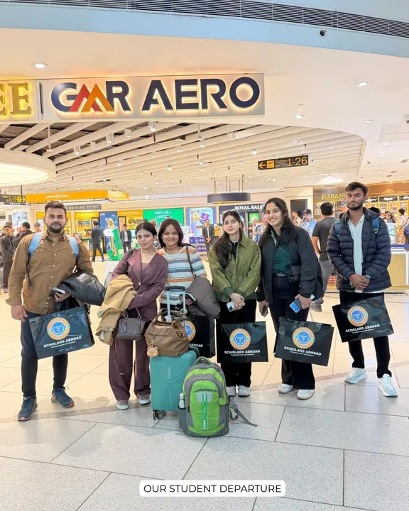 A group of students at the airport with luggage and Scholars Abroad bags