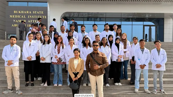 Students in white coats with Scholars Abroad representatives outside Bukhara State Medical Institute