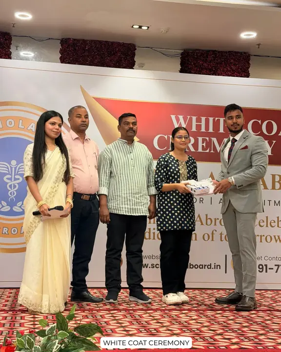 A student with family members and Scholars Abroad representatives at a white coat ceremony