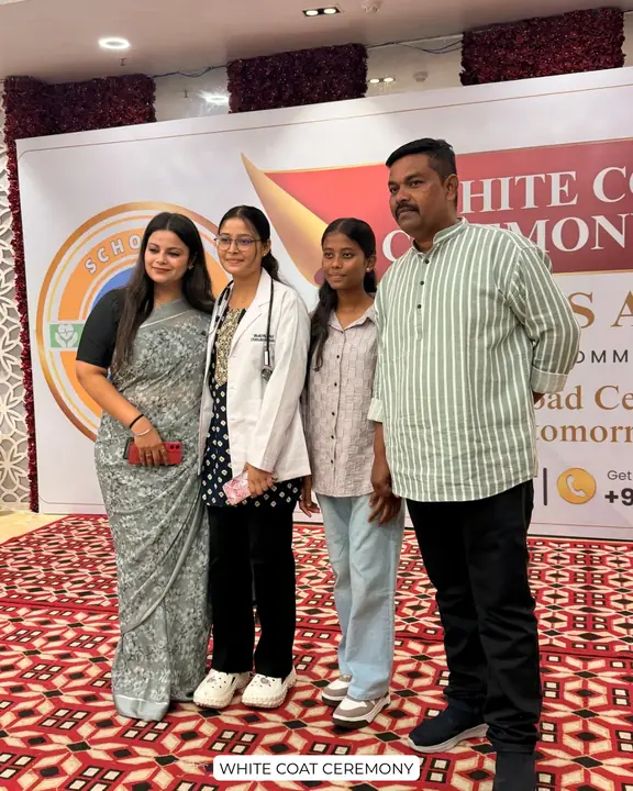 A student wearing a white coat with family at a Scholars Abroad ceremony