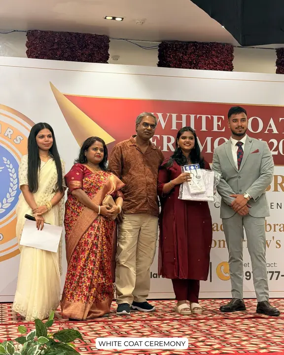 A student holding a ceremony gift beside family and Scholars Abroad representatives