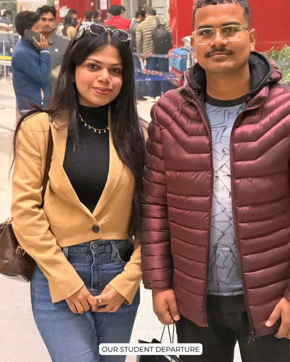 A student in a maroon jacket with a Scholars Abroad representative at the airport
