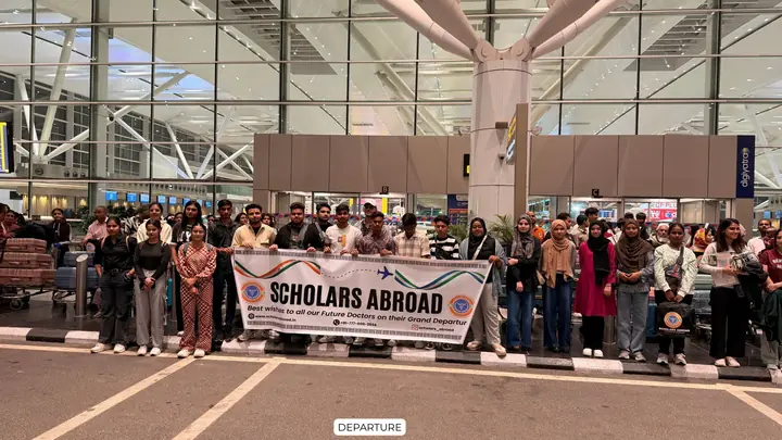 Students and families at an airport with a Scholars Abroad departure banner