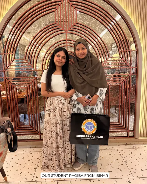 Raqiba with a Scholars Abroad representative holding a Scholars Abroad bag