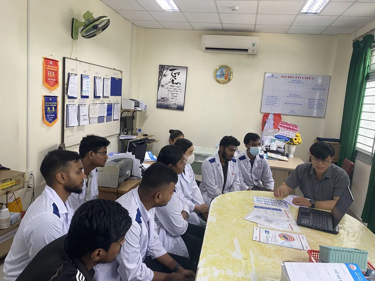 Medical students discussing documents with a supervisor in a teaching room, from HIU's international programme page