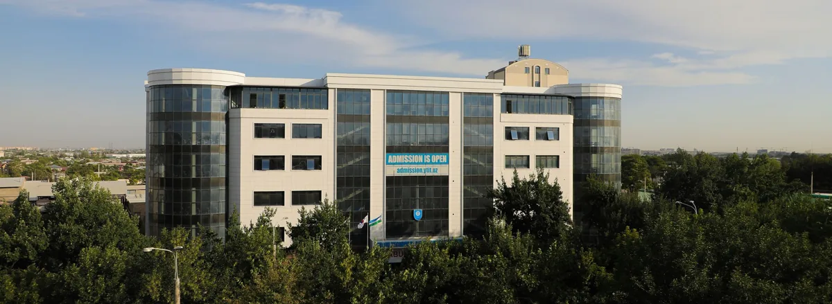 Kimyo International University campus building in Tashkent with trees and glass-fronted teaching blocks